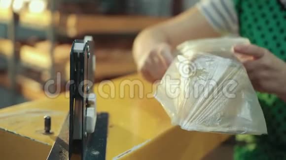 女工在金属机上用塑料薄膜包好面包视频的预览图