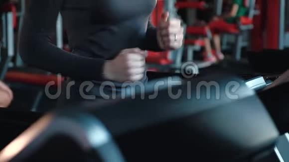 一个年轻女孩在健身房的特殊跑步机上训练的精致腰部视频的预览图