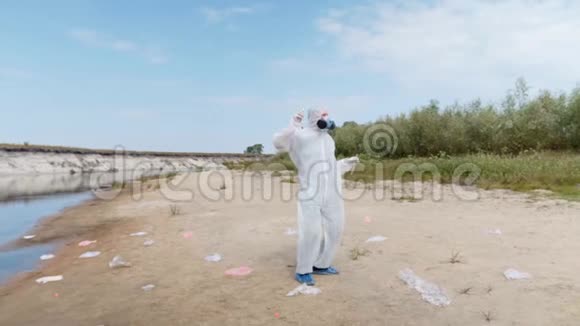 穿着防护服戴着防毒面具的男子在干涸污染的河边表演一支流行舞蹈视频的预览图
