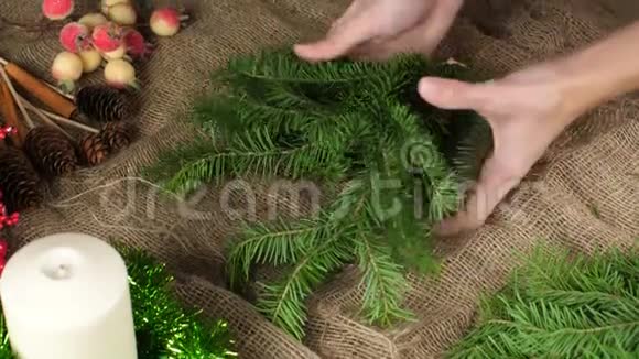 一个花店的女手几乎不撕下一小片云杉创造一个圣诞作文转移分支视频的预览图
