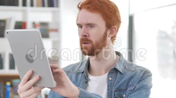 临时红发男子在使用平板电脑时应对损失视频的预览图