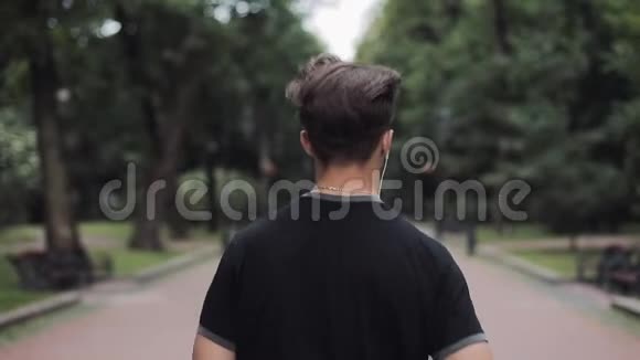 高加索青年男子在耳机运行在公园后侧视概念健康生活方式视频的预览图