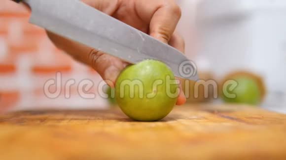 女人用刀子把青柠切成碎片放在厨房的木板上视频的预览图