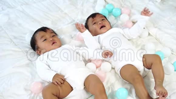 两个双胞胎婴儿躺在床上一个在看一个在哭视频的预览图