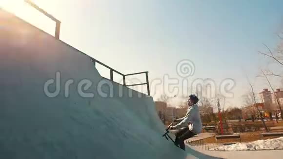 一个bmx骑手在溜冰场训练他们的技能在明亮的阳光下奔跑表演一个翻转动作视频的预览图