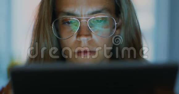 高质量的4k12位镜头年轻的办公室工作人员在笔记本电脑上打眼镜找出问题深夜视频的预览图