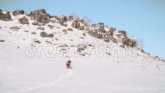 一座巨大的山上覆盖着积雪和裸露的岩石它升起了一大群挂着特殊装备的登山者视频的预览图