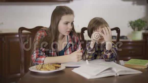 姐姐和弟弟一起做作业坐在家里的桌子旁小男孩没有成功视频的预览图