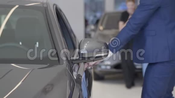 商人在现代经销商中选择汽车高个子男人开门坐在汽车陈列室里关门视频的预览图
