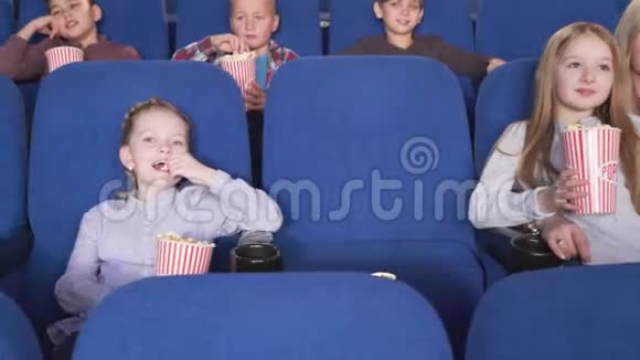 快乐的男孩和女孩看有趣的电影视频的预览图