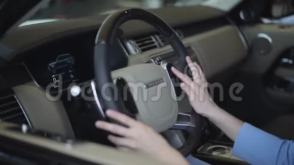 女士用她的手触摸方向盘并触摸控制面板关闭现代女孩检查汽车视频的预览图