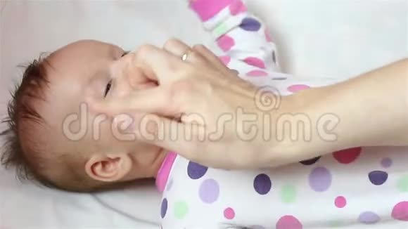 妈妈在她的脸颊上涂抹了一种新生的医用保湿凝胶视频的预览图