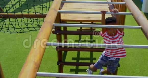 非裔美国小学生在学校操场上横梯玩耍的高视角视频的预览图