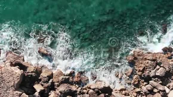 大浪的高空俯视图岩石海岸的无人机射击具有极端波浪的海洋海岸线波浪撞击岩石波浪碰撞视频的预览图