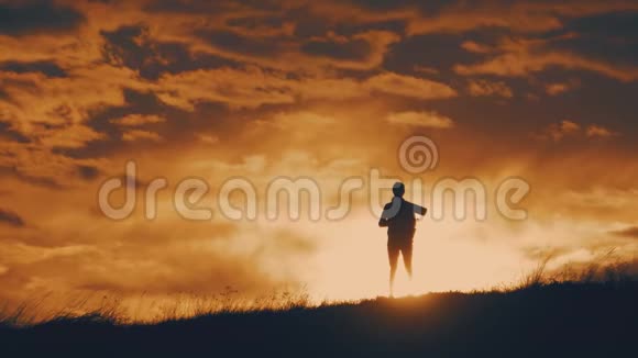 剪影年轻女孩带着背包从山顶欣赏日落日落时分的游客人民视频的预览图