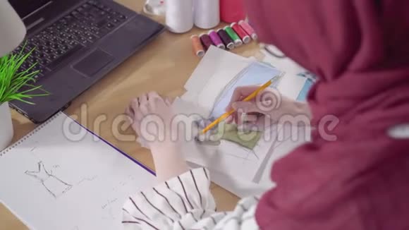 年轻的穆斯林女时装设计师在国家头巾做素描视频的预览图
