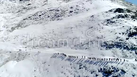 一大群游客在冬天的雪山上一排爬上去空中飞行医生视频的预览图