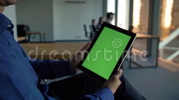 西班牙裔企业家拿着一台绿色屏幕的黑色平板电脑没有脸视频的预览图