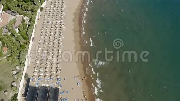 在海边的沙滩上游客在遮阳伞和遮风挡雨视频的预览图