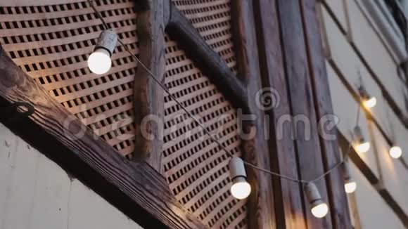 木制百叶窗上挂着一个灯泡花环LED灯照亮街道视频的预览图
