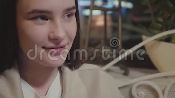 特写一位坐在餐馆里的漂亮年轻女子的肖像女人的脸上下打量视频的预览图
