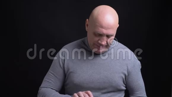 用显示绿色屏幕的平板电脑拍摄中年白种人秃头的特写镜头他的拇指向上视频的预览图