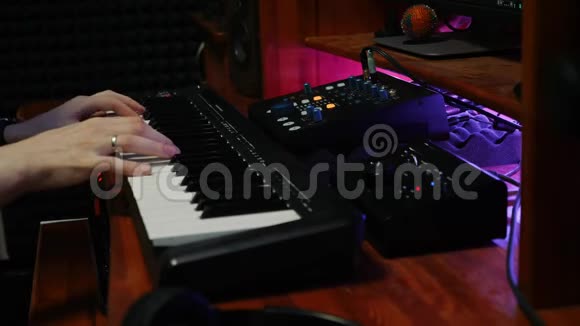 声音工程师在数字音频工作站混合和掌握音乐作家弹钢琴MIDI键盘家庭音乐视频的预览图