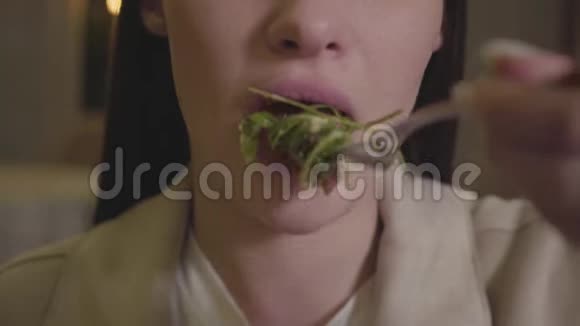 年轻的女人正在吃阿鲁古拉沙拉下颚的女孩在餐厅享用她的健康食物视频的预览图