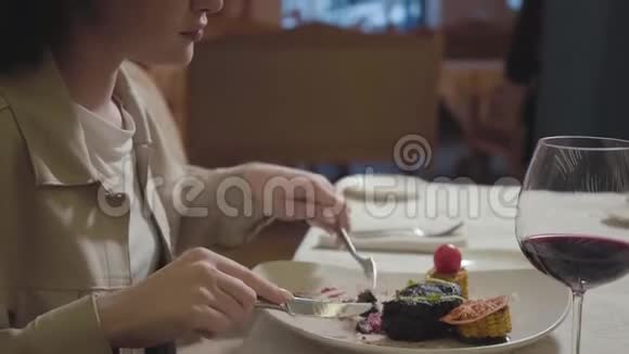 肖像年轻女子吃着美味的牛肉或羊肉配上烧烤玉米和西葫芦配上一杯视频的预览图