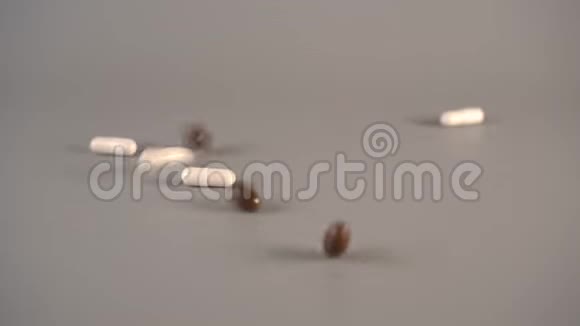 棕色和白色的医疗胶囊落在木桌上视频的预览图