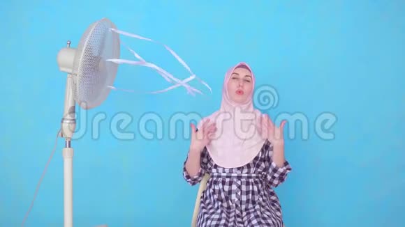 年轻的穆斯林妇女遭受炎热天气的冷却风扇视频的预览图