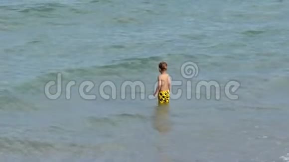 小男孩在海滩上玩视频的预览图