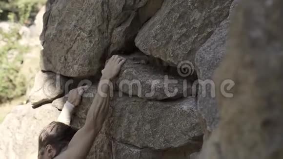 运动员攀岩者在悬崖上攀爬伸手抓住系上安全绳视频的预览图