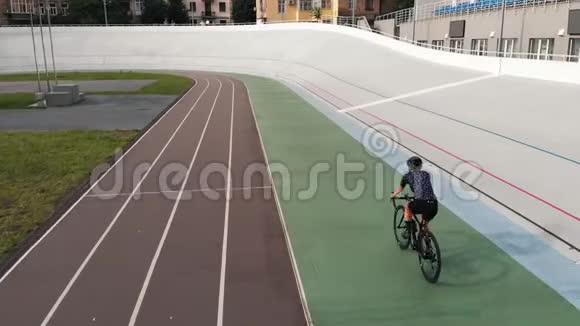 骑公路自行车的女自行车手正在赛车场训练自行车跑道上骑自行车的运动女孩的特写镜头在赛车场训练视频的预览图