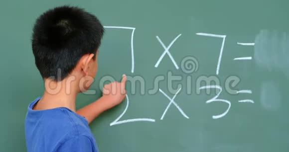 亚洲小学生在学校教室用黑板解决数学问题的后视图视频的预览图
