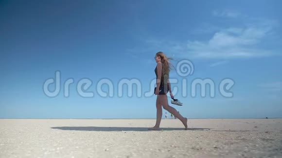 穿短裤的莱吉女孩走在一个废弃的海滩上经过稻草真菌视频的预览图