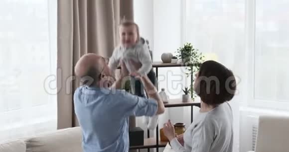 祖父母把可爱的女婴抬到空中视频的预览图