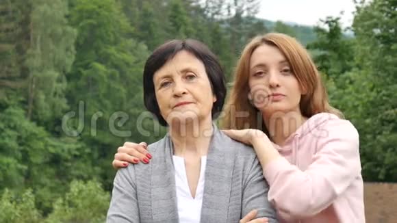 一幅严肃的母亲和成年女儿在夏天群山背景下的肖像快乐的晚年视频的预览图