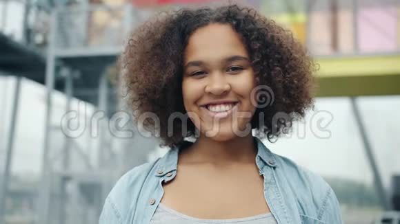 迷人的非洲裔美国青少年在户外微笑的特写肖像视频的预览图