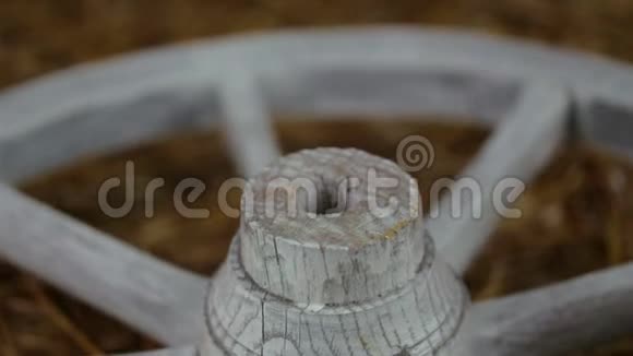 一个古老的白色木轮躺在干草和旋转视频的预览图