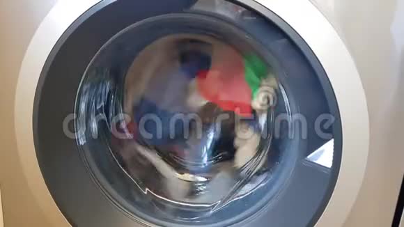 洗衣机洗彩色衣服和床单圆筒旋转用干净的彩色衣服在洗衣机上特写视频的预览图