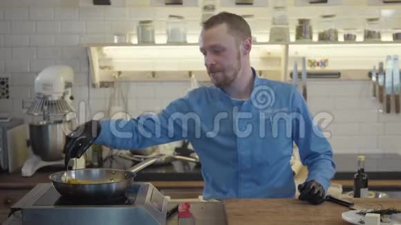 厨师炊具黑色手套风琴或炖片西葫芦和玉米在一个热锅与油的背景视频的预览图