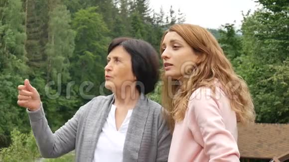 两个女人年轻的和年长的正在眺望远方在群山和视频的预览图