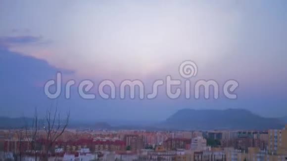 镜头转向直到我们看到一个多山城市的美丽景色紫色和红色的多云天空一只鸟飞过视频的预览图