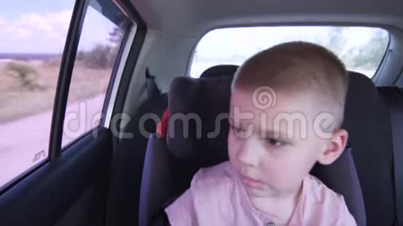 一个疲惫的小男孩坐在孩子们座位上视频的预览图