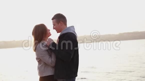 幸福浪漫的情侣在夕阳下拥抱男人亲吻女孩视频的预览图