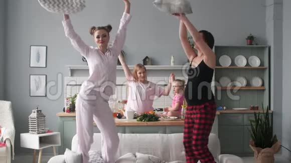 有趣快乐的女人在家里跳舞打枕头仗视频的预览图