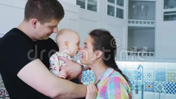 白色厨房内部的父亲母亲和新生儿视频的预览图