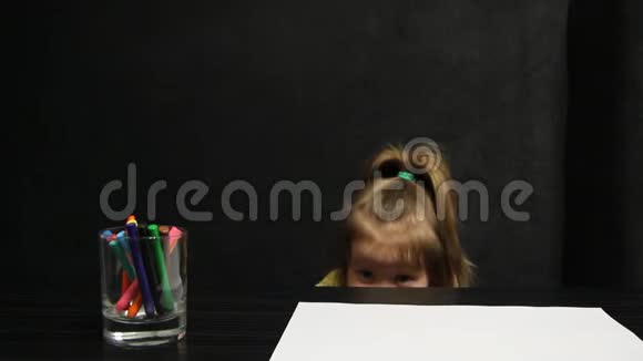 小女孩躲在桌子下面画画也许她害怕什么视频的预览图