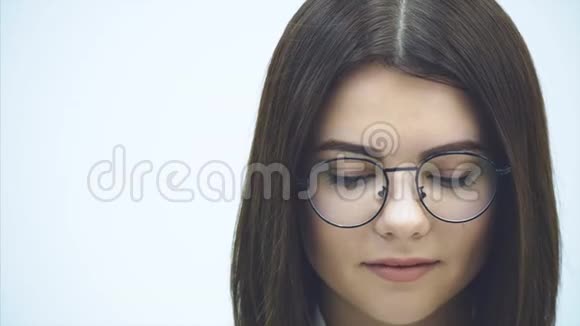 戴着眼镜的漂亮女商人歪着脸看着镜头笑得可爱视频的预览图